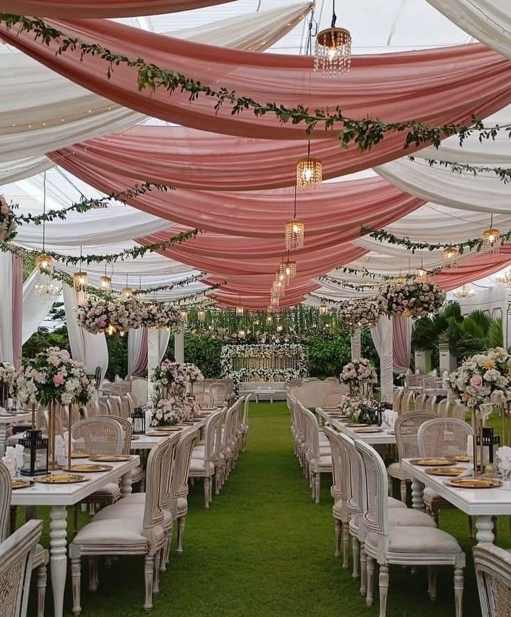 Blush and white draped wedding tent with floral chandeliers